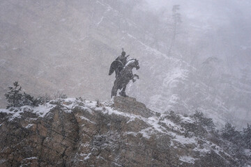 Obraz premium View of Uastyrdzhi monument in Urukh river canyon at winter snowfall. Mountain Digoria, North Ossetia, Russia.