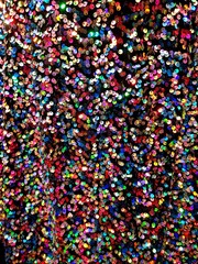 Colorful shiny sequin fabric texture, red, yellow, blue, fun fashion bg background