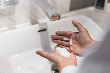 Close up of people washing hand with liquid soap carefully.