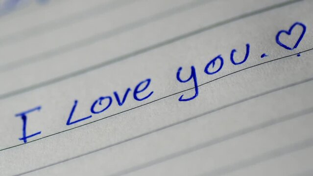 The pen that is writing on the paper I love you