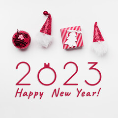 New Year holiday greeting card, Christmas decor and text 2023 Happy New Year. Striped paper red gift box, funny dwarf with sequins, Christmas mirror ball, wooden fir tree form, holiday concept © yrabota