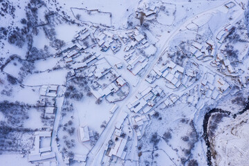 Aerial top view of covered with snow Makhchesk village on winter day. Mountain Digoria, North Ossetia, Russia.