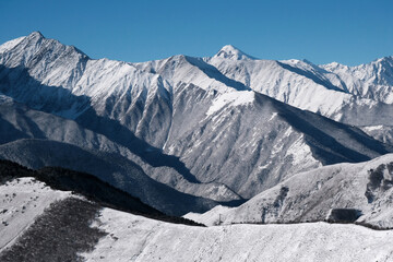 View of Caucasian Mountain Range from Tsey Loam pass on sunny winter day. Ingushetia, Caucasus, Russia.