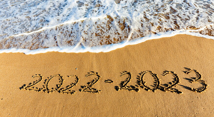 Fototapeta premium Jahreszahl 2022-2023 in den Sand geschrieben