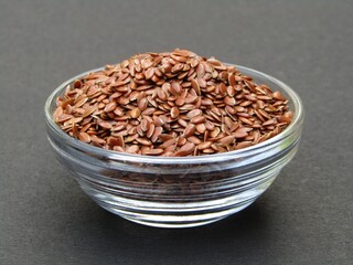 Flax seeds in a bowl on black background 