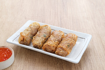 Lumpia Kulit Tahu, chicken shrimp spring rolls wrapped in tofu skin. Served with sauce.
