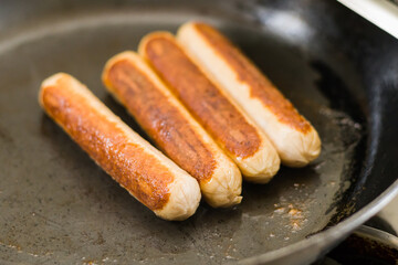sausages being fried in a pan for breakfast. it is a staple breakfast food made of chicken, beef or...
