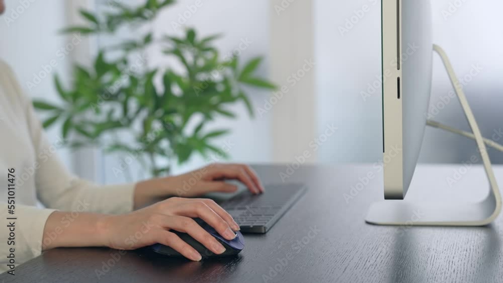 Poster close-up of a woman's hand using a desktop computer in the office.
