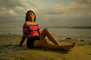 Fototapeta na wymiar Asian girl on the beach at sunset