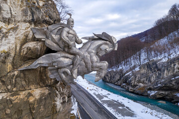 View of Nyhas Uastyrji monument and Ardon river on cloudy winter day. Alagir gorge, North Ossetia, Russia.