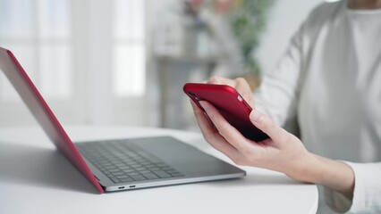 Woman using smartphone and laptop in office. smartphone authentication. biometric authentication. Security. - Powered by Adobe