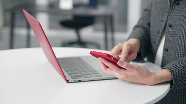 Woman using smartphone and laptop in office. smartphone authentication. biometric authentication. Security.