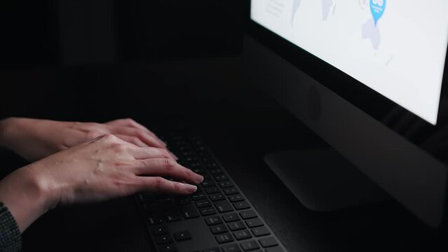 暗い部屋でタイピングする女性
