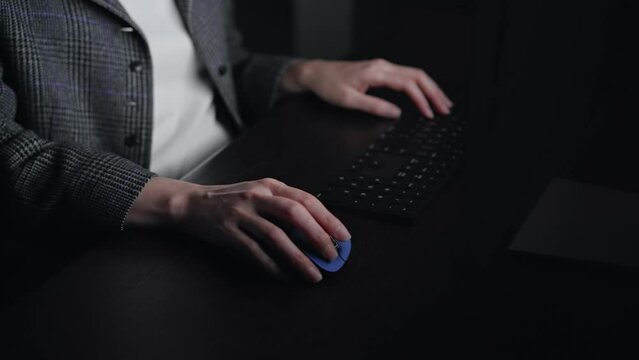 暗い部屋でパソコンを使う女性