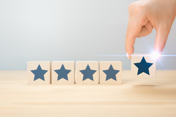 customer hand arranging five wooden cubes with star. Ranking and customer satisfaction concept. 5...