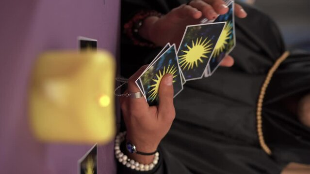 Close-up of a male fortune teller reading tarot cards.