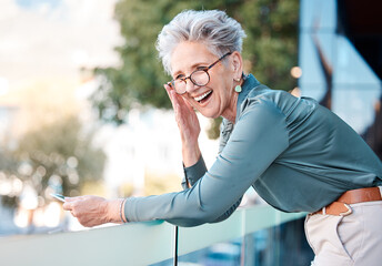 Phone, funny and city with a business woman outdoor standing on a the balcony of her office at...