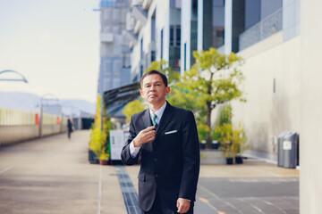 Middle-aged Asian man in black business suit at Kyoto station, Japan.