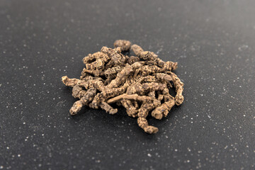 Valerian roots in a pile on a black cutting board side view