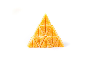 Saffron spiced sugar cubes stacked in a pyramid isolated over white side view