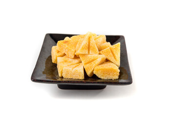 Saffron spiced sugar cubes in a pile on a black tray side view