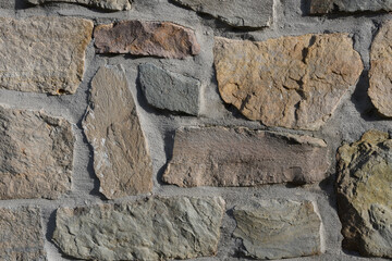 Large hand-cut stones in a free layout. Texture of old stone. Marble and stone wall background. .