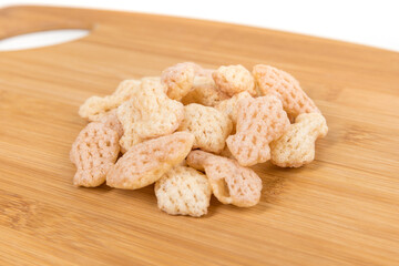 Cuttlefish snack crisps in a pile on a wood cutting board