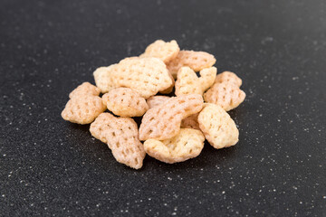 Cuttlefish snack crisps in a pile on a black cutting board