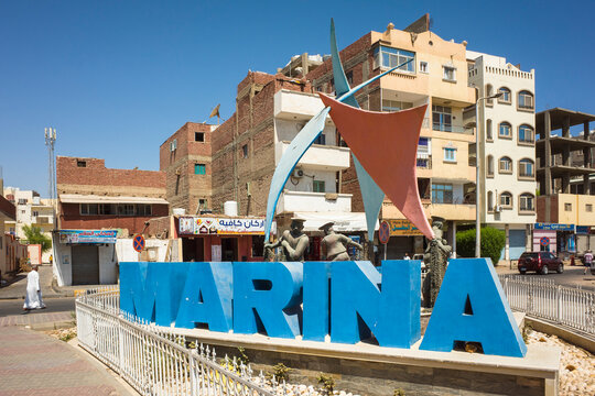 Hurghada, Red Sea Governorate, Egypt - September 21, 2022: Hurghada Marina sign sculpture and residential buildings in city