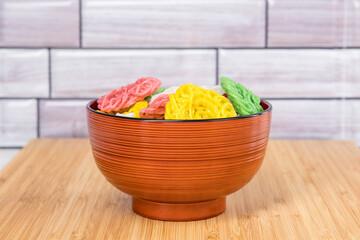 Raw multicolored tapioca crackers in an orange bowl