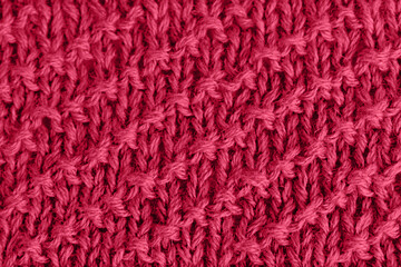 Viva Magenta trendy color 2023 knitted background in red jersey. Knitted fabric.