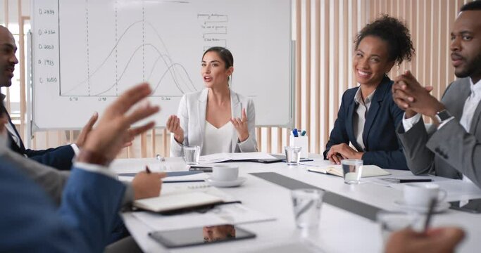 Business people, meeting and budget with graph on board with happy, smile and laugh in office. Business meeting, table and diversity for planning, strategy and target for finance company in New York