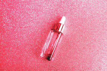 Cosmetic purple serum bottle on sparkling viva magenta background. Skincare, spa and wellness...