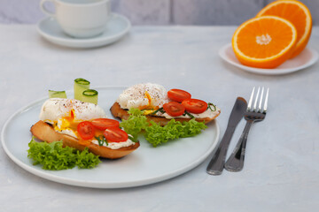 Poached egg toast with tomato and cream cheese and bread on a plate. Healthy food concept.