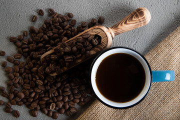 Blue cup of coffee with roasted coffee beans
