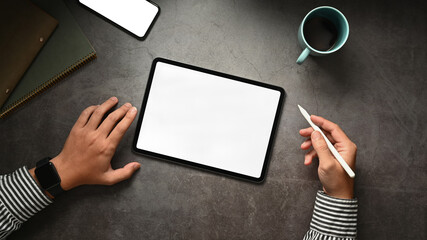 Above view of modern businessman using digital tablet on black stone table. Blank screen for your advertise design