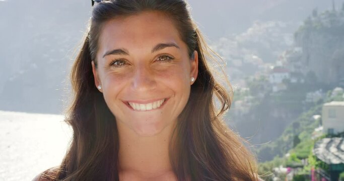 Travel, summer and face of woman with smile enjoy summer holiday, vacation and journey in Italy. Freedom, happiness and portrait of girl bite lip for tourism, travelling and adventure in nature