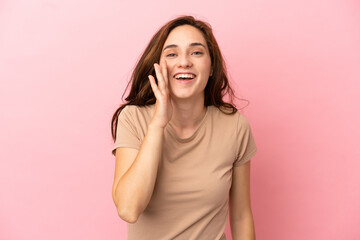 Young caucasian woman isolated on pink background shouting with mouth wide open