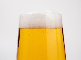 Glass of beer on a white background. A glass of light beer with foam.