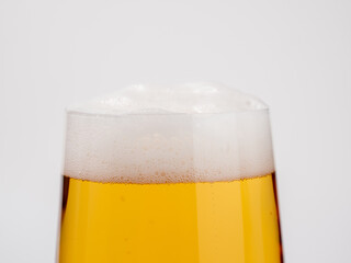 Glass of beer on a white background. A glass of light beer with foam.