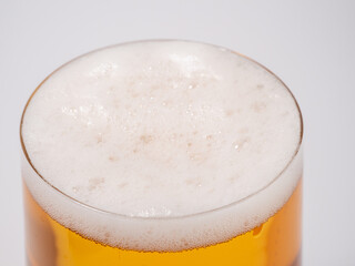 Glass of beer on a white background. A glass of light beer with foam.