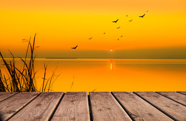 paisaje de un lago con un atardecer anaranjado