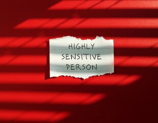 Torn note stick on red background with text HIGHLY SENSITIVE PERSON, refers to people who think and...