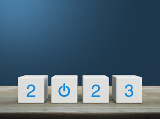 2023 start up business icon on white block cubes on wooden table over light blue wall, Happy new year 2023 success concept