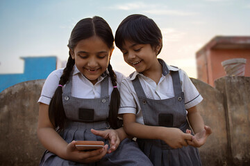 Rural Indian school school girls playing game in smartphone