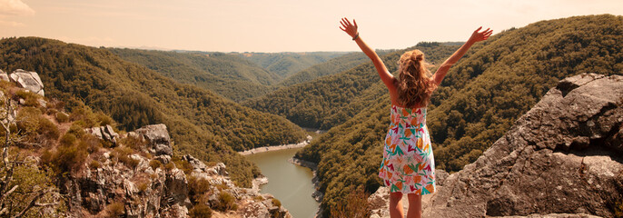 Woman on peak enjoying panoramic dordogne river view