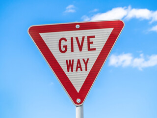 Give way road sign on blue sky background