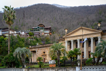 Fototapeta na wymiar An antique-style building on the background of mountains in the city of Gagra, Abkhazia, in winter
