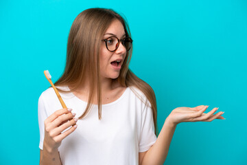 Young Lithuanian woman brushing teeth over isolated background with surprise facial expression