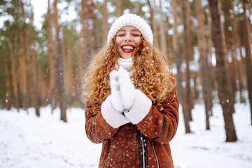 Happy young woman in the winter forest. Christmas, winter holidays concept.